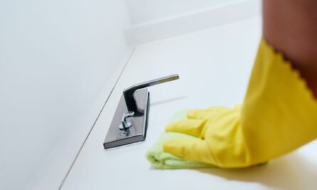 Person With Gloves Disinfecting Door Knob Using Sanitizer
